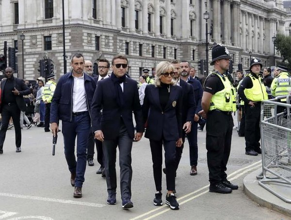 에마뉘엘 마크롱(가운데 왼쪽) 프랑스 대통령 부부가 18일 엘리자베스 2세 영국 여왕의 관이 안치된 웨스트민스터 궁전 방문을 위해 런던 거리를 걸어서 이동하고 있다. 런던=EPA 연합뉴스